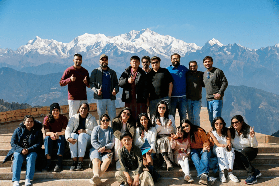Tripjyada travelers together beneath Himalayan peaks