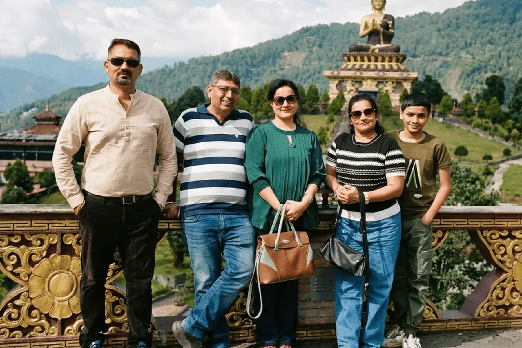 A Tripjyada family at Buddha Park, Ravangla, Sikkim, with the giant Buddha statue behind them
