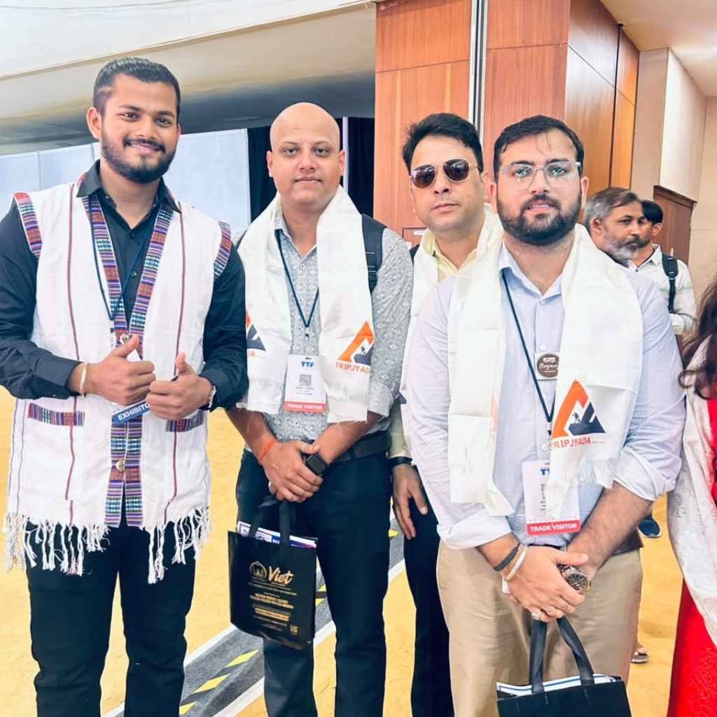 Tripjyada representatives wearing white scarves at a travel industry event