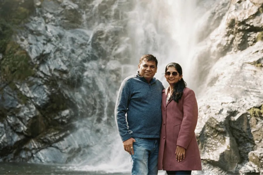A couple enjoying a stop beside a Himalayan waterfall